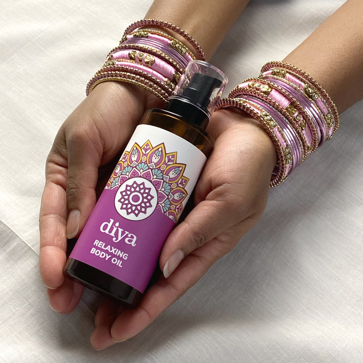 Vino holding a bottle of Diya relaxing body oil