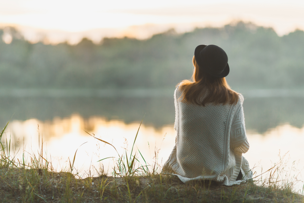 Girl sitting on a peaceful riverside